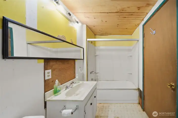 Additional full bath featuring a classic tub-to-ceiling surround.