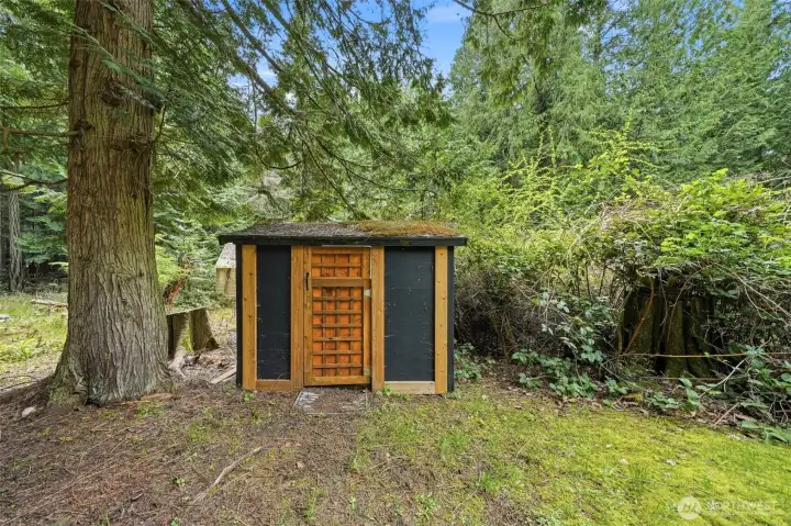Charming shed tucked into the trees.