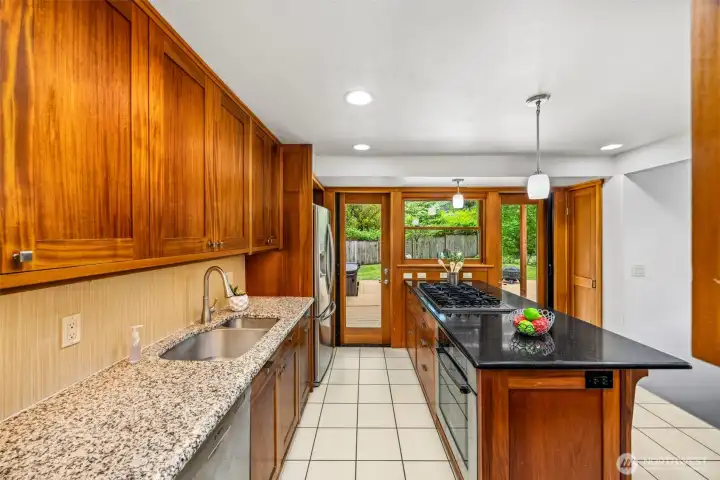 Two tone granite countertops with 2 doors leading to outdoor deck so you can cook and entertain at same time