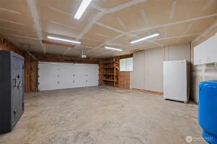 Virtually cleaned 2 car garage, shows the expansion tank for the well, freezer that conveys and the safe that is negotiable with an offer.