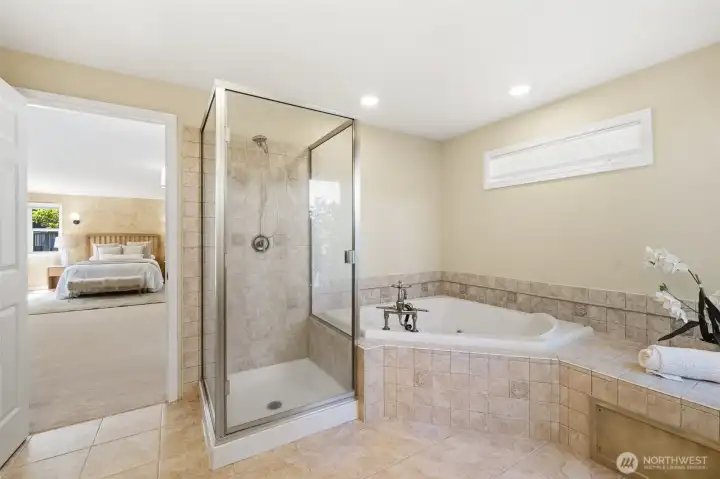 Tiled floor, jetted tub, and stand up shower complete the primary bathroom.