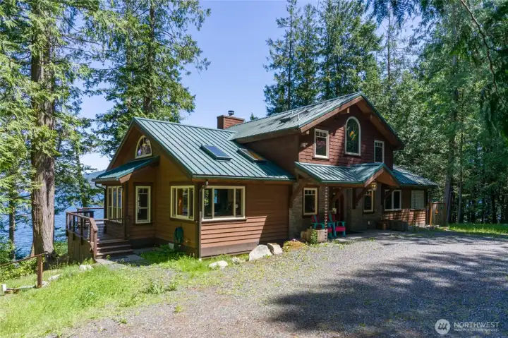 Front entrance to the home with covered frront door, big windows for natural light, hugged by the forest. Front entrance to the home with covered frront door, big windows for natural light, hugged by the forest.
