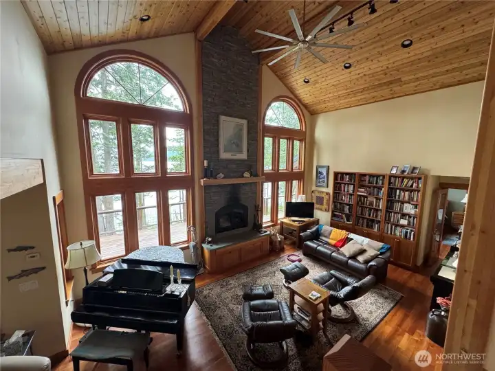 A wall filled with floor to ceiling windows, showcasing the views that explain why we want to be by the sea. Wood fireplace, built in shelving, hardwood floors, vaulted ceiling. A wall filled with floor to ceiling windows, showcasing the views that explain why we want to be by the sea. Wood fireplace, built in shelving, hardwood floors, vaulted ceiling.