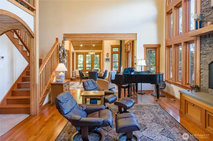 Looking into dining/sitting area from living room. Stairway up to second level where a second primary ensuite and library are located. Looking into dining/sitting area from living room. Stairway up to second level where a second primary ensuite and library are located.