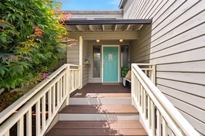 A warm, welcoming covered entry, with charming seating area and peaceful views of the surrounding greenery.