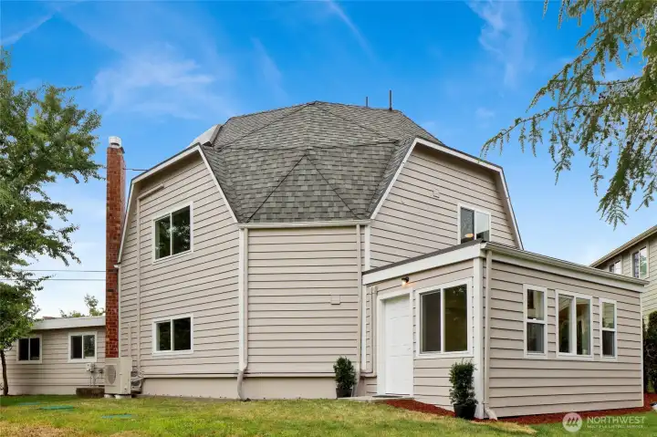 The rear of the home features a private entrance to the lower level, opening into a bright sunroom surrounded by windows The rear of the home features a private entrance to the lower level, opening into a bright sunroom surrounded by windows