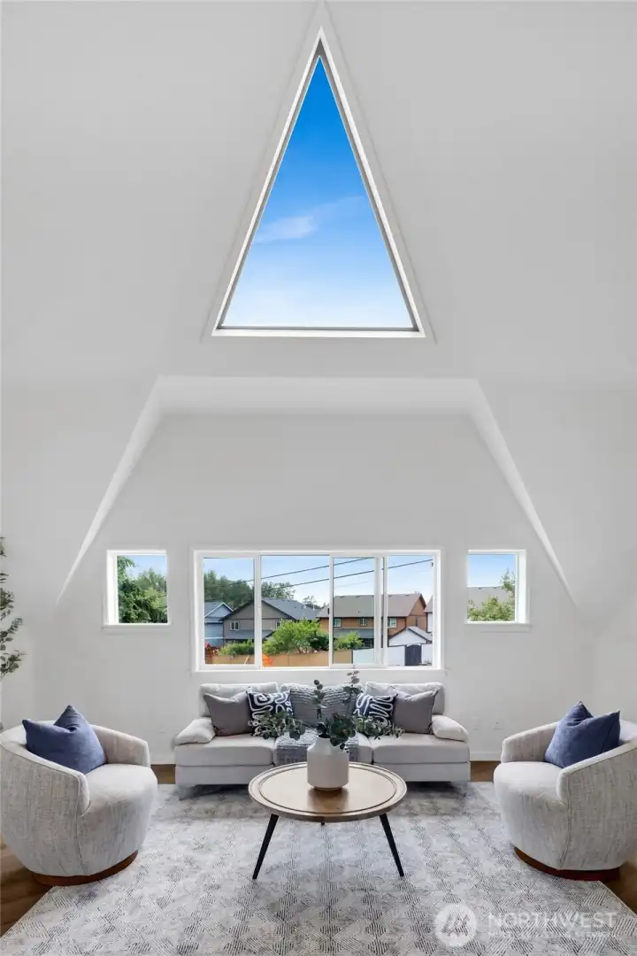 Vaulted ceilings and expansive windows fill the living room with natural light, creating a warm and welcoming gathering space. Vaulted ceilings and expansive windows fill the living room with natural light, creating a warm and welcoming gathering space.