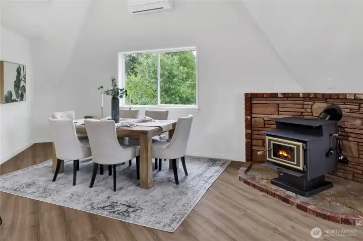 Enjoy meals in this bright dining area featuring dramatic vaulted ceilings and a cozy wood-burning fireplace that adds warmth and character to the space. Enjoy meals in this bright dining area featuring dramatic vaulted ceilings and a cozy wood-burning fireplace that adds warmth and character to the space.