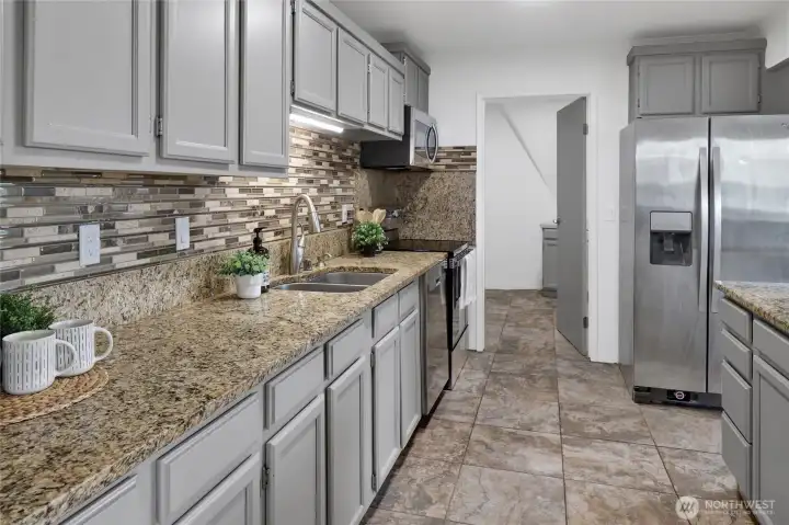 Enjoy a functional kitchen with convenient access to a large utility room featuring the main-level laundry, abundant storage, and plenty of space to organize pantry essentials, small appliances, and household supplies. Enjoy a functional kitchen with convenient access to a large utility room featuring the main-level laundry, abundant storage, and plenty of space to organize pantry essentials, small appliances, and household supplies.