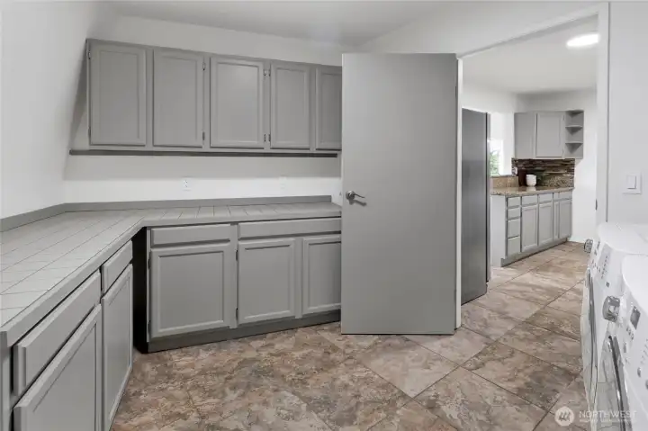 Large utility/laundry room adjacent to the kitchen, providing ample space for laundry, organization, extra storage, or a generous walk-in pantry. Large utility/laundry room adjacent to the kitchen, providing ample space for laundry, organization, extra storage, or a generous walk-in pantry.