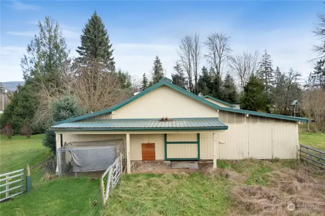 Side of barn and dog run and fenced horse pasture.