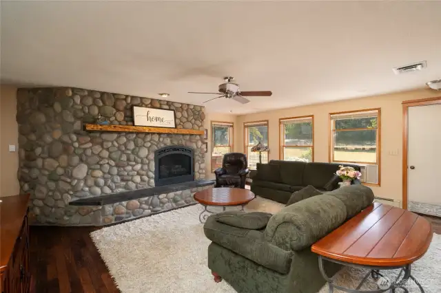 Cozy living space with beautiful river rock propane fireplace with Yew wood mantel with raise hearth. Dark Oak hardwood floors and Anderson double hung wood clad windows with low-e glass & screens.