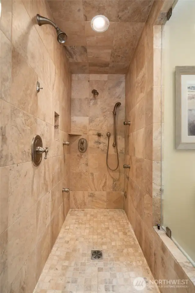 Walk in travertine tile shower with multi head spray and steam shower. Glass in shower has been treated with special coating to help stay clean.