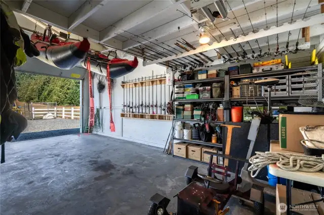 Large bay in shop with concrete floors and boiler heat as needed. 4 large bays 2 12x12, 1 12x10 & 1 8x8 roll-up doors.  Loft space, covered area behind shop has additional storage for boat, tractor, horse stalls and wood storage.