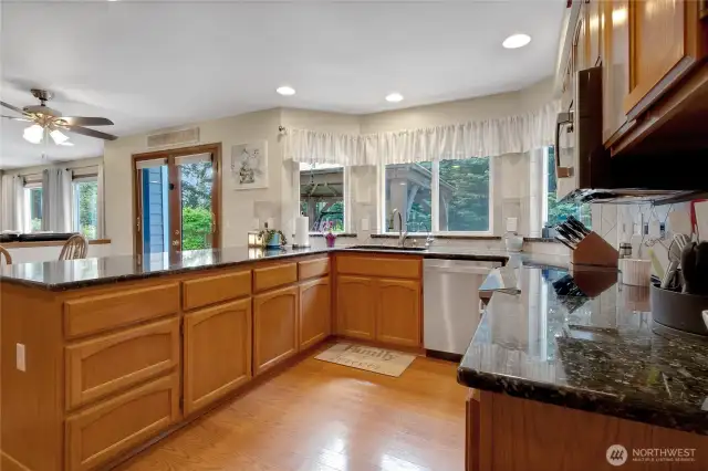Beautifully designed kitchen featuring granite countertops, stainless steel appliances, and an induction oven. Enjoy a gorgeous view of the backyard from the sink, along with the convenience of a pantry and an eating bar. Thoughtfully located off the dining room, it’s perfect for gatherings, with an adjacent eating area that adds to the functionality and flow.