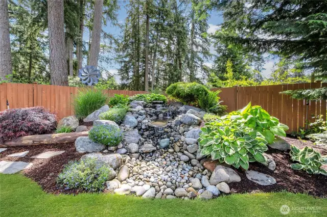 Tranquil setting with a cascading waterfall surrounded by lush, mature landscaping. This serene water feature creates a peaceful ambiance, perfect for relaxing or unwinding in total privacy