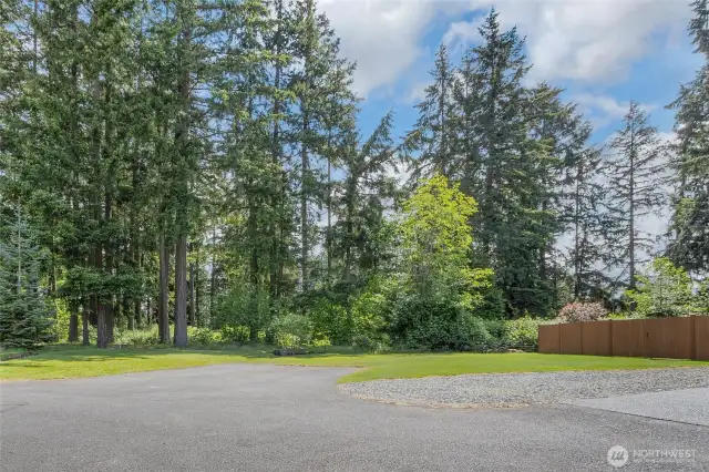 Additional parking pad and gravel area offer ample space for extra vehicles and RV parking, with double gates providing convenient access to the backyard.