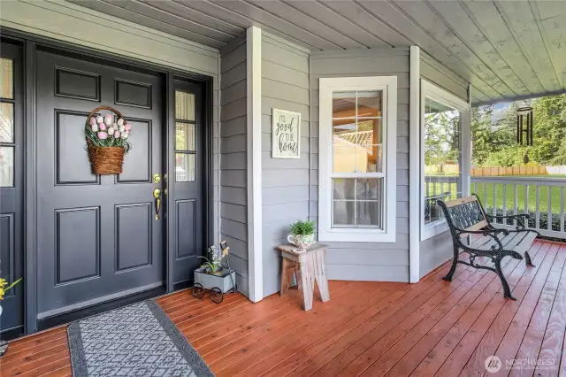 Charming covered front porch with warm wood decking and classic curb appeal! Enjoy peaceful mornings or relaxing evenings from this welcoming space, perfect for sipping coffee or greeting guests. A bubbler fountain nestled within the beautiful landscaping adds a soothing sound, creating a tranquil atmosphere to unwind and enjoy the surroundings.