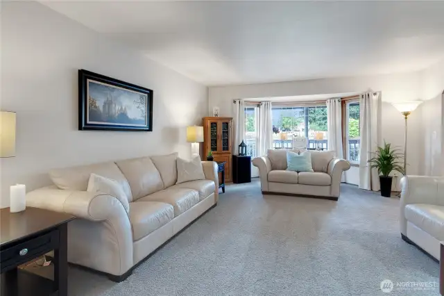 Elegant living room featuring large windows that allow abundant natural light to illuminate the space while providing picturesque views of the outdoors