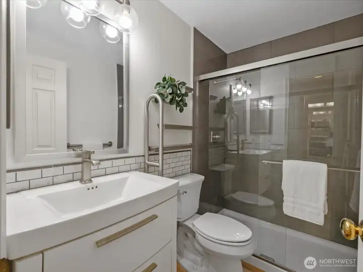 The completely updated, elegant guest bathroom with double sized, tiled shower.