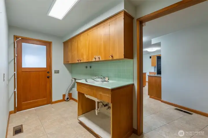 Great storage in the laundry room with built in cabinets on the wall behind.