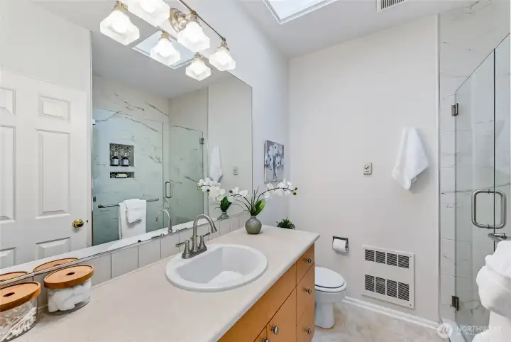 The spacious primary en-suite bathroom has been beautifully updated, combining modern style with comfort.