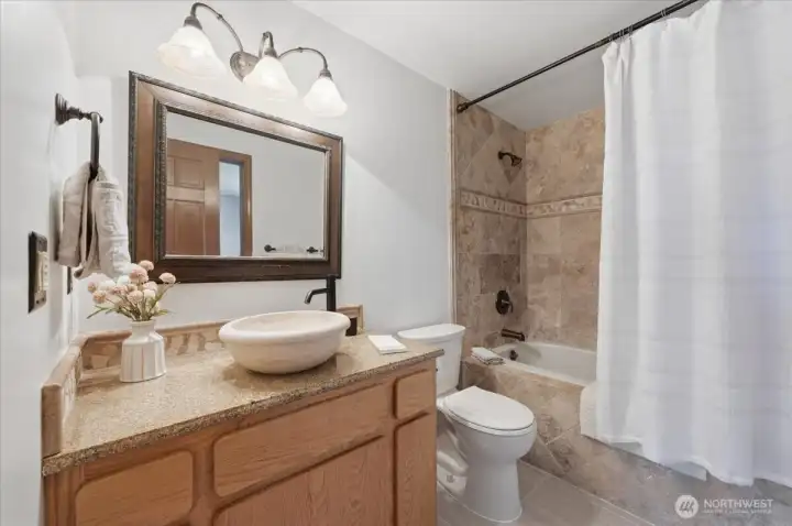 This full bath with a Granite counter-top, Travertine sink & shower/tub surround and Porcelain Flooring, accommodates the other 2 large bedrooms both with walk-in closets.