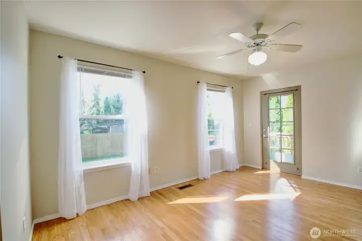 The bright master bedroom faces the backyard. Door at the far end leads outside.