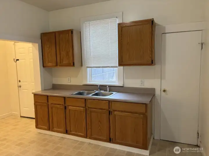 Roomy kitchen! The door to the right leads to the bathroom, the door on the left leads out to the back yard. Roomy kitchen! The door to the right leads to the bathroom, the door on the left leads out to the back yard.