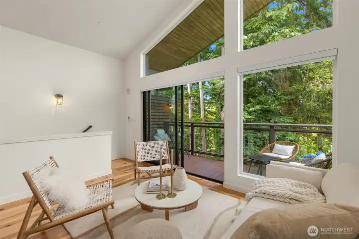 The third-floor great room is where the home opens up — vaulted ceilings, a wall of glass, and a canopy of Douglas Firs that feels both private and alive. Cook, gather, settle in.