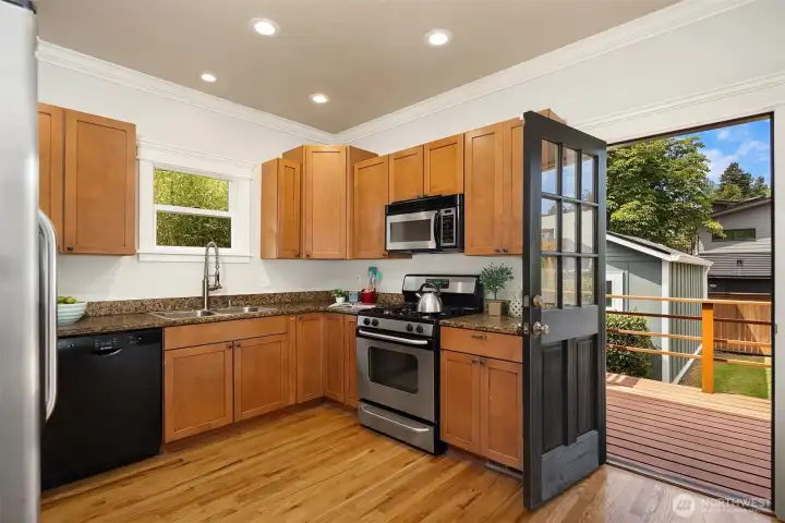 Remodeled kitchen with maple cabinets, slab granite counters, and a gas cooktop. Plus great access to the back deck and fully fenced backyard - more on that later!