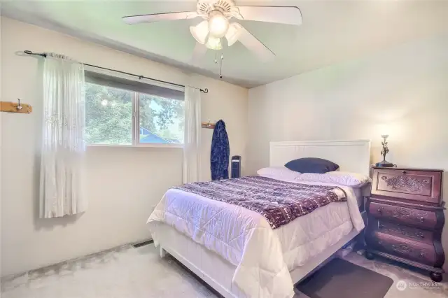 Master bedroom with private backyard view and attached private bathroom and beautiful fan/light.