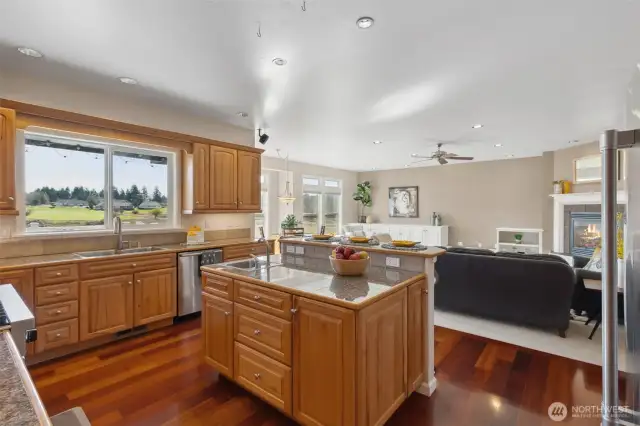 Cooking just became a social affair in this gorgeous kitchen! With a second sink on the island for all your prep needs and a charming pot holder hanging above, you’ll have everything at your fingertips. The raised bar seating invites family and friends to gather, making it easy to connect while you whip up your favorite dishes. And let’s not forget the stunning window view of the backyard and Mt. Rainier—a perfect backdrop for your culinary adventures.