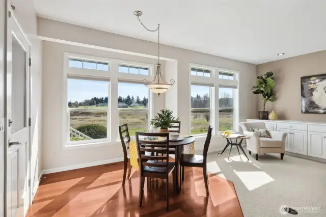 This casual dining area is graced with a beautiful swagged chandelier, creating a warm and inviting atmosphere for meals or late-night chats. Oversized windows overlook the backyard, letting in plenty of light and showcasing your easy-care landscaping. The classic white trim adds that extra touch of elegance.