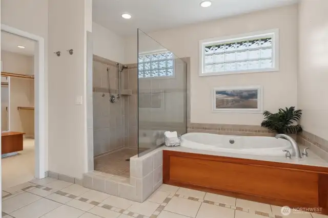 Soak it all in! This primary suite bathroom is your personal retreat, complete with a sumptuous soaking tub that promises relaxation like no other. The stylish tile floors set the stage for luxury, and the tiled-in shower with a glass wall and adjustable shower head makes shower time feel like a spa experience. With a glass block privacy window adding a touch of modern flair, you can enjoy your tranquil oasis without a worry in the world. It’s all about pampering yourself here!