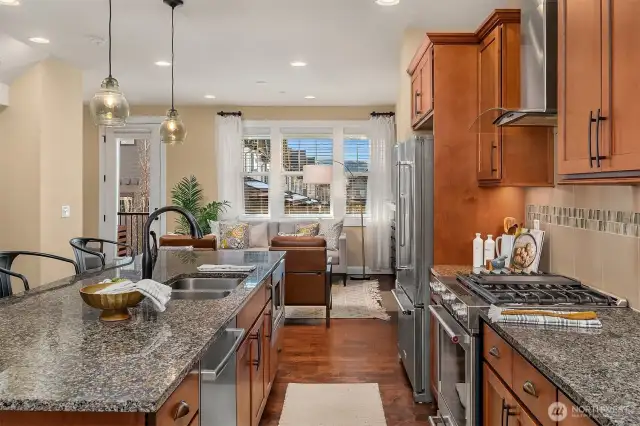 The open kitchen is highlighted by the warm wood cabinets, stainless appliances and sleek countertops.