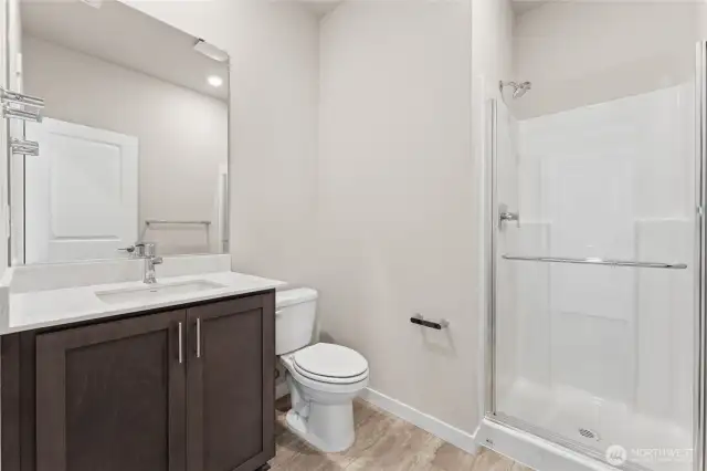 Main floor 3/4 bathroom with step in shower. Photo is representational. Home is under construction and finishes, room dimension, features, and colors may vary. See site agent for details.