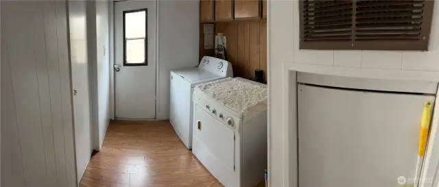 Laundry room with door to the outside and cabinets