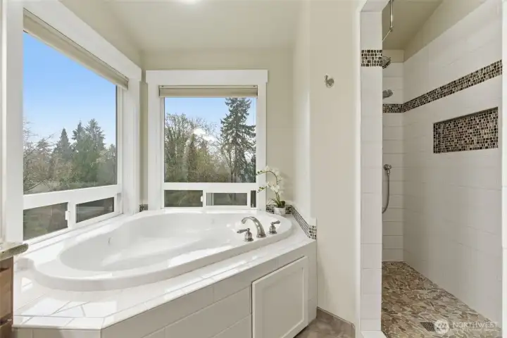 Second floor primary bathroom, jetted tub with view and large walk-in shower with a bench.