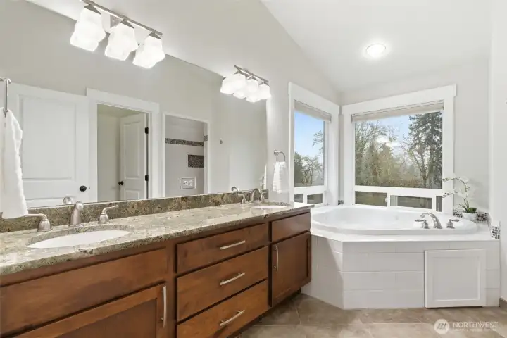 Second floor primary bath, featuring two sinks, soft close drawers, granite countertops, and vaulted ceilings.