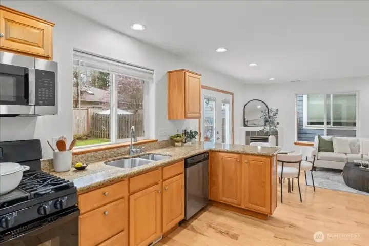 Kitchen with granite counters, appliances, and an extended breakfast bar. Open layout provides clear sightlines to the living area and dining space.