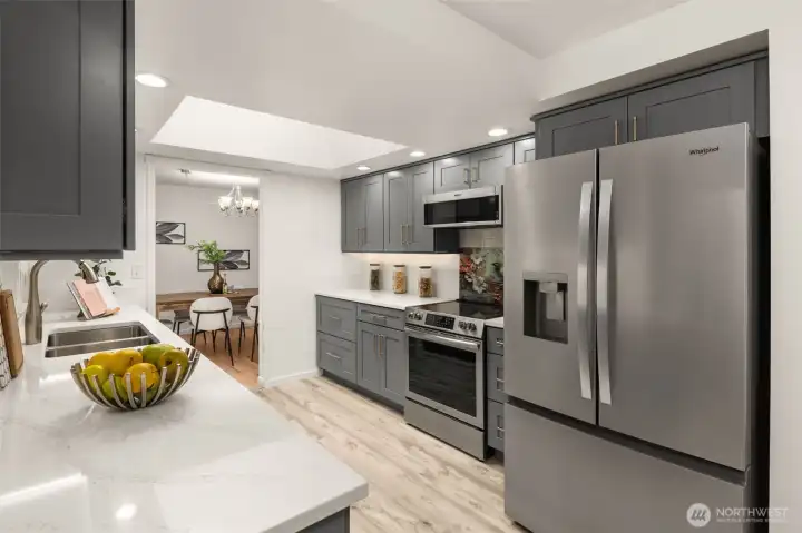 Remodeled kitchen with quartz countertops, custom cabinetry, stainless appliances, and abundant storage.