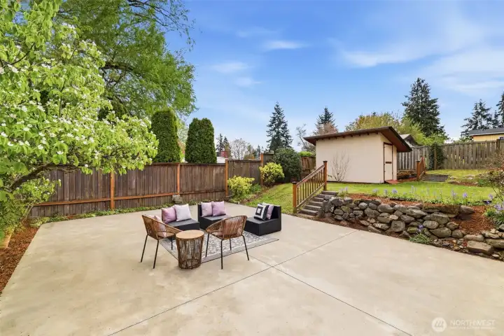 Large patio ideal for entertaining with terraced yard and storage shed