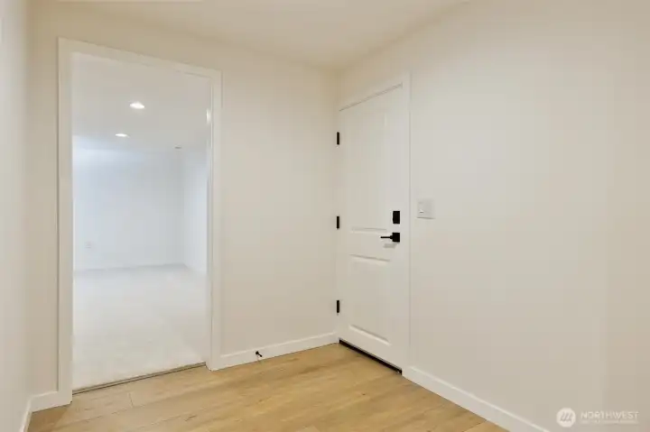 Hallway connecting the primary suite with downstairs living area and garage access