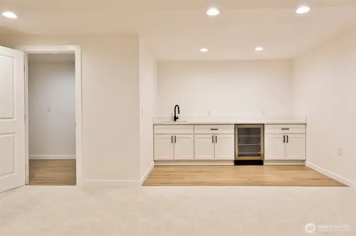 oversized laundry room and wet bar/kitchenette space with under mount sink and refrigerator