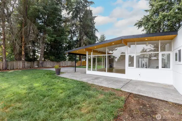 Expensive wraparound back patio with covered seating area and integrated lighting