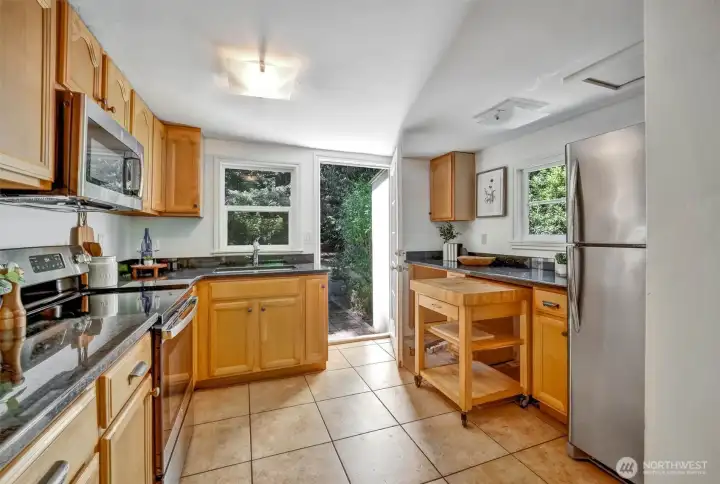Full kitchen view with washer/dryer space. Has hook up . Or you can use a European washer dryer in one space and tuck the cutting board in the other.