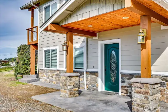 The porch on the driveway side is covered with a small patio outside the door.