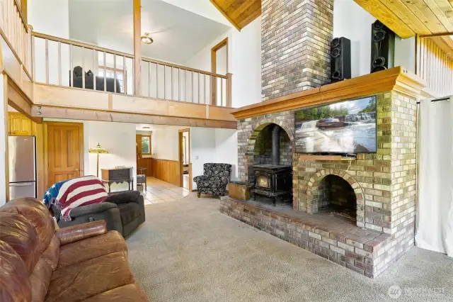 Living room with floor to ceiling brick fireplace.