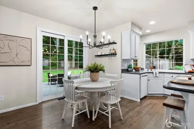 A breakfast nook provides an informal place for daily meals and offers a glimpse to the private backyard brimming with lush green foliage and trees.